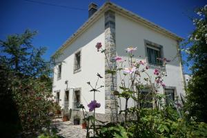 uma casa branca com flores à frente em Casa Maricuelo em Castropol