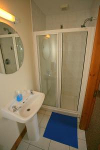 a bathroom with a white sink and a shower at Cottage Heights in Castletownbere