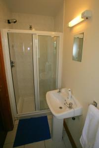 y baño con lavabo blanco y ducha. en Cottage Heights en Castletownbere