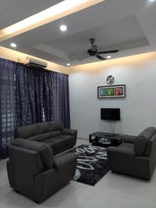 a living room with two couches and a tv at Amanda Homestay Dungun 1 in Dungun