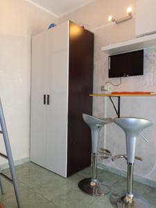 ガリポリにあるmini appartamento per due a Gallipoliの白いキャビネットと2つのスツール付きのキッチン