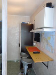 ガリポリにあるmini appartamento per due a Gallipoliの小さなキッチン(テーブル、スツール2脚付)