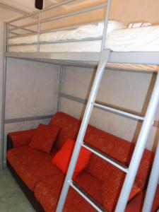 ガリポリにあるmini appartamento per due a Gallipoliの二段ベッド1組(赤いソファ付)が備わる客室です。