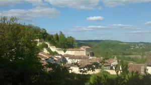 a village on a hill with houses and trees at lembaudie in Saint-Privat-des-Prés