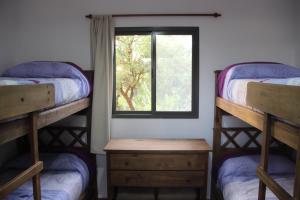 a room with two bunk beds and a window at Cabañas El Arcano in Capilla del Monte +29 photos