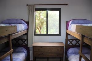 Habitación con 2 literas y ventana en Cabañas El Arcano en Capilla del Monte