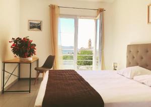 a bedroom with a bed and a table and a window at Casale a Figa Bianca in Patrimonio