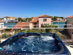 a hot tub on the balcony of a house at Villa L'Amiraute in Agde
