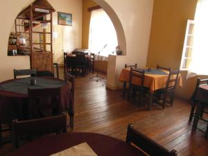 a dining room with tables and chairs and a window at Three Palms Fianar in Fianarantsoa
