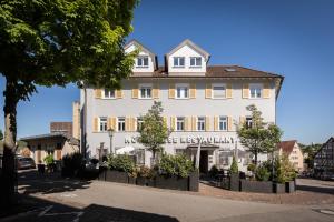 ein großes weißes Gebäude mit einem Schild drauf in der Unterkunft Hotel & Restaurant Rose in Bietigheim-Bissingen