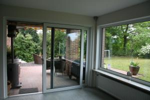 un porche cubierto con puertas correderas de cristal en Ferienwohnung Kiel-Russee, en Kiel