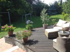 una terraza de madera con sofá y algunas plantas en Ferienwohnung Kiel-Russee en Kiel