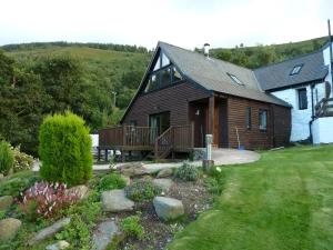 a house with a porch and a deck in a yard at Dee Valley Cottages in Llangollen