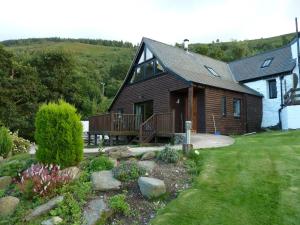 ein Haus mit einer Veranda und einer Terrasse im Hof in der Unterkunft Dee Valley Cottages in Llangollen