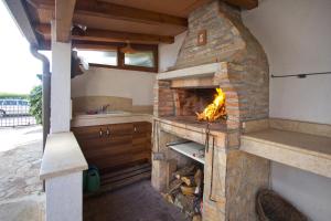 uma cozinha com um forno de pedra no meio em Beach House - Sea Breeze em Poreč