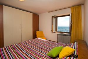 een slaapkamer met een bed met gele en groene kussens bij Sea Breeze in Poreč