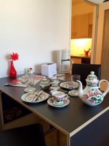 a table with plates and cups and tea sets on it at Klein und fein in Oberstaufen