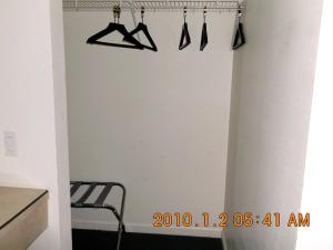a hallway with hangers hanging from a wall at Green Gables Inn in Cody +3 photos