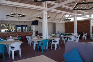 a restaurant with tables and chairs and a bar at Family Hotel Happy INN in Zatoka