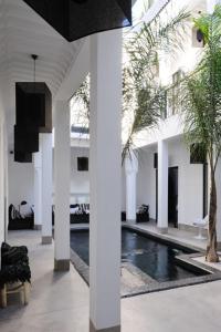 a room with a swimming pool in a building at Riad First in Marrakesh