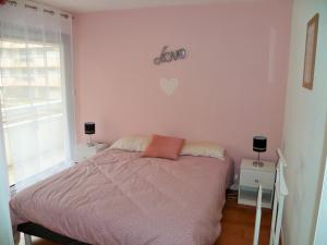 ル・テュケ・パリ・プラージュにあるResidence les Serresのピンクの壁のベッドルーム1室