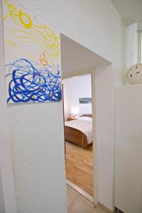 1 dormitorio con 1 cama y una pintura en la pared en San Apartment, en Makarska