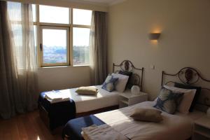 ヴィラ・ノヴァ・デ・ガイアにあるSpectacular Views Penthouse Apartmentのベッド2台と窓が備わるホテルルームです。