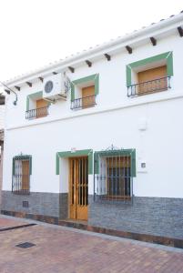 un edificio blanco con puertas y ventanas marrones en Casa Felix, en Segura de la Sierra