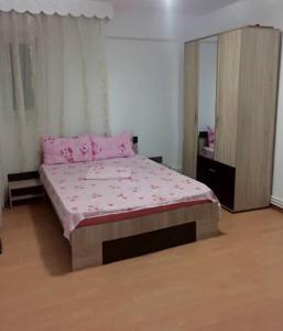 コンスタンツァにあるBeatryce Apartmentのベッドルーム1室(ピンクのシーツと鏡付きのベッド1台付)