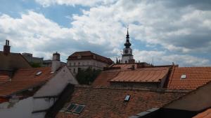 uma torre de relógio no topo de telhados de edifícios em Apartmány Holiday em Třebíč