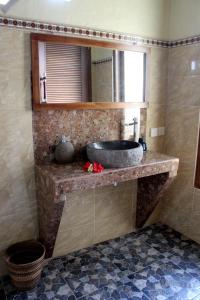 a bathroom with a sink and a mirror at Maha Neka Villa in Sidemen