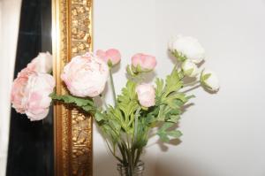 een vaas met roze bloemen voor een spiegel bij Vakantiehuis in Oosterwolde