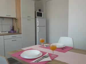 una cucina con tavolo e 2 bicchieri di succo d'arancia di Studio apartman Toplica a Daruvar