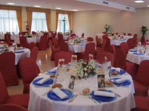 un salón de banquetes con mesas blancas y sillas rojas en Sommelier Hostelera SL, en Fonolleres