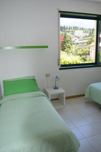 ein Schlafzimmer mit einem grünen Bett und einem Fenster in der Unterkunft BRIONE47 in Riva del Garda