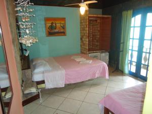 sypialnia z różowym łóżkiem w pokoju w obiekcie Pousada Flamingo w mieście Búzios