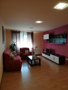 sala de estar con sofá rojo y mesa en Castelao Apartments, en Arzúa