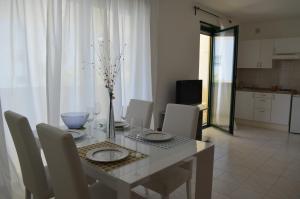 ein Esszimmer mit einem Tisch und Stühlen sowie eine Küche in der Unterkunft BRIONE47 in Riva del Garda