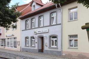 ein weißes Gebäude an der Straßenseite in der Unterkunft Hotel Bierstübl in Sangerhausen