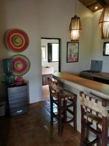 a kitchen with a bar with two chairs and a laptop at El Respiro Ecolodge in Granada