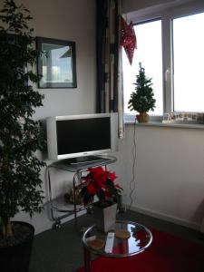 uma sala de estar com um monitor de computador e uma árvore de Natal em B&B De Beverhoek em Roggel