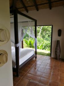 Schlafzimmer mit einem Bett mit Glastür in der Unterkunft El Respiro Ecolodge in Granada