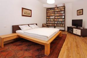 a bedroom with a bed and a book shelf at Villa Z - apartment with private parking in Brno