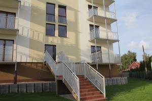 apartamentowiec ze schodami prowadzącymi do niego w obiekcie Apartament Kapitański Bursztynowe Komnaty w Darłówku