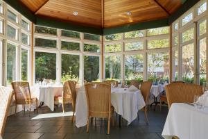 a dining room with tables and chairs and windows at Lismoyne Hotel in Fleet
