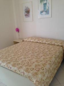 łóżko w sypialni z narzutą w obiekcie Capoliveri Punta Morcone bilo w mieście Capoliveri