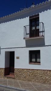 ein weißes Gebäude mit 2 Fenstern und einem Balkon in der Unterkunft Dayma in Medina-Sidonia