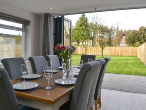 un tavolo da pranzo con sedie e una grande finestra di Ancrum House a Gretna Green