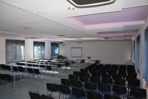 una sala de conferencias con mesas, sillas y una pantalla en Hotel Monttis, en Sucha Beskidzka