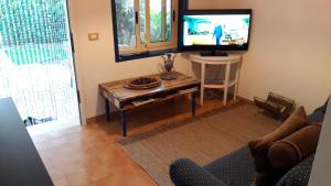 a living room with a tv and a coffee table at Villa Amenta in Fontane Bianche